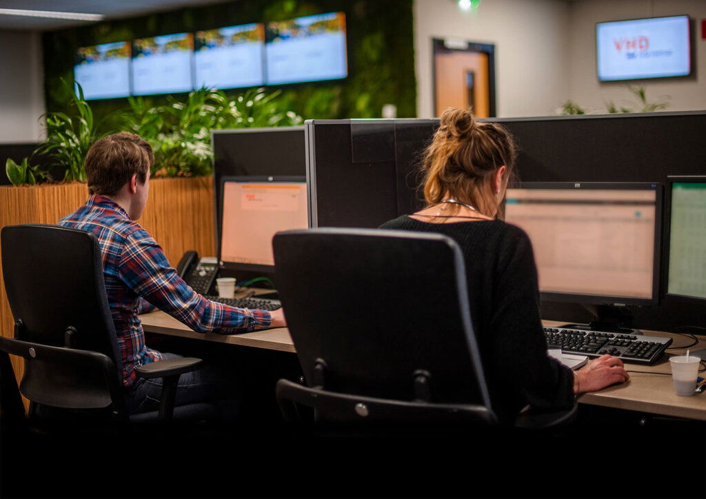 Op de afbeelding is te zien hoe medewerkers van de alarmcentrale van VHD zich in zetten om mensen in binnen- en buitenland vlot verder te helpen.