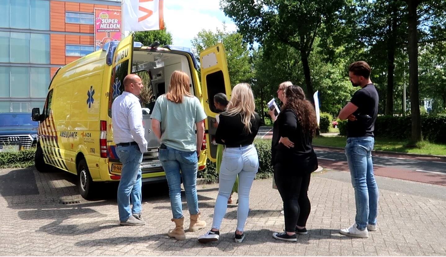 Een impressiebeeld van een trainingsdag bij VHD. Deze keer voor de afdeling Travel. Een groep centralisten kijkt in een ambulance.