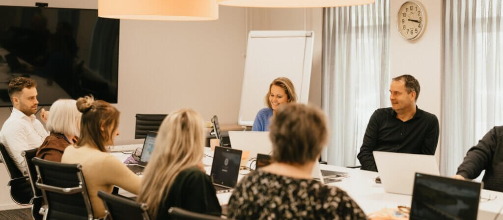Foto van de teamleiders van VHD rondom een tafel in overleg.